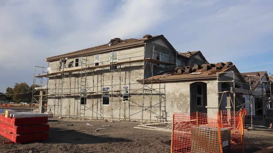 Two-story house exterior with windows and a tiled roof.